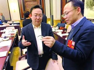 昨天,北京團(tuán)小組會(huì)休息的間隙,程京代表(右)向夏林茂代表介紹基因芯片。張宇攝